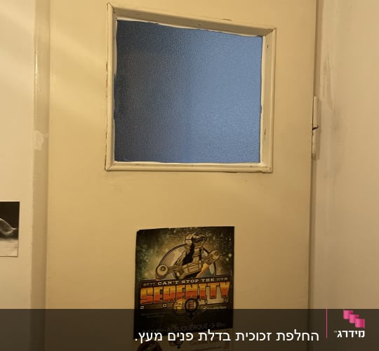חלון זכוכית מט במרכז דלת עץ
